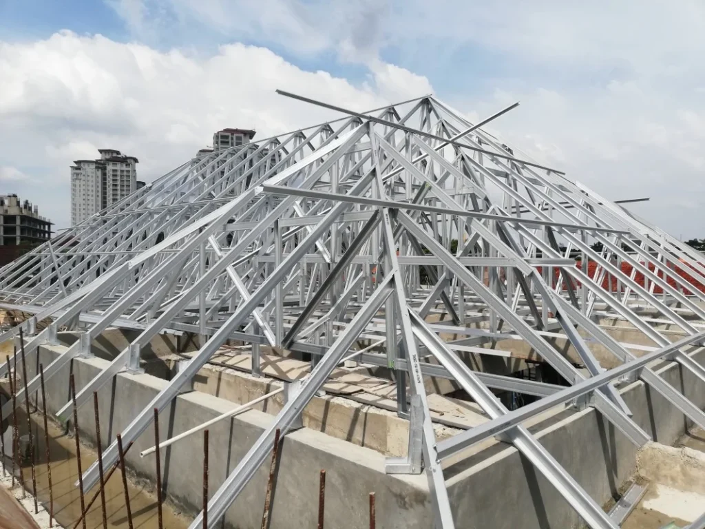 Rangka atap baja ringan yang sedang dalam proses pemasangan genteng beton di sebuah proyek rumah tinggal.