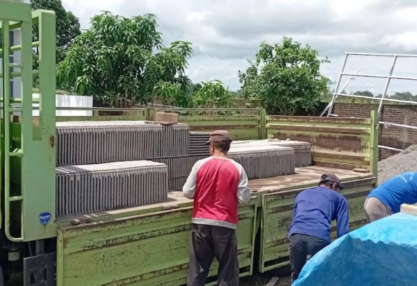 Genteng beton disusun berdiri di bak truk saat pemuatan